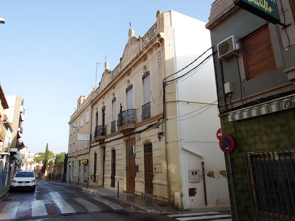 Narrow street in Godella lined with historic townhouses with ornate facades and iron balconies