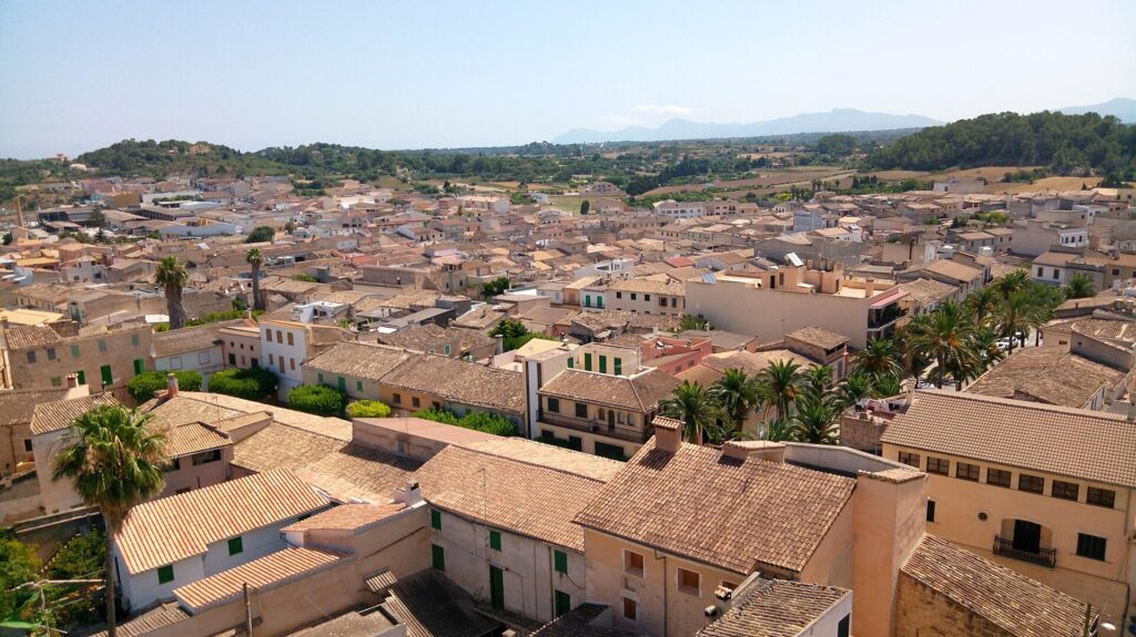 Rooftops of the town of Santa Margalida in Mallorca seen from the church tower, with fields and hills beyond