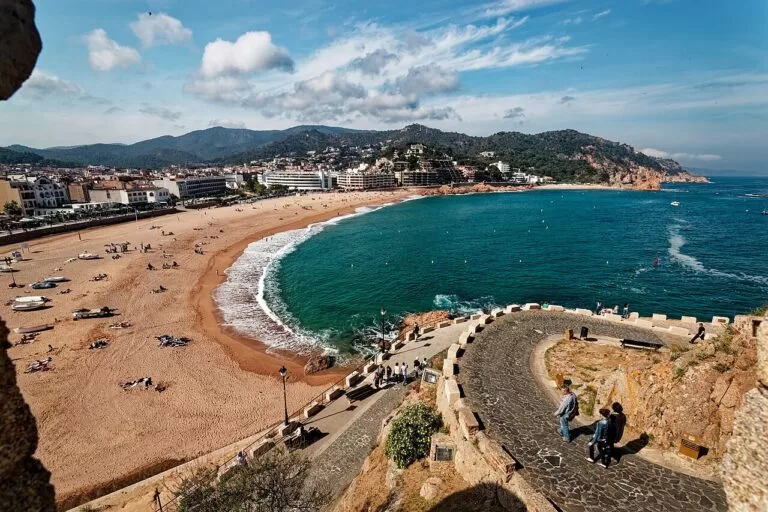 The curved Platja Gran beach of Tossa de Mar seen from the old town walls