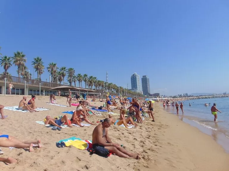 Sunbathers on the sand of Barceloneta beach in Barcelona