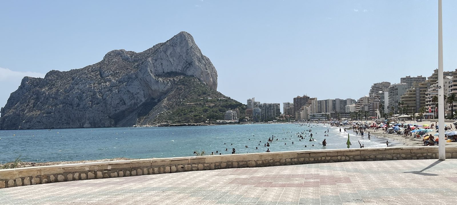 The Peñón de Ifach rising over the Arenal-Bol beach at Calpe, seen from the seafront promenade, with the town's apartment blocks along the bay