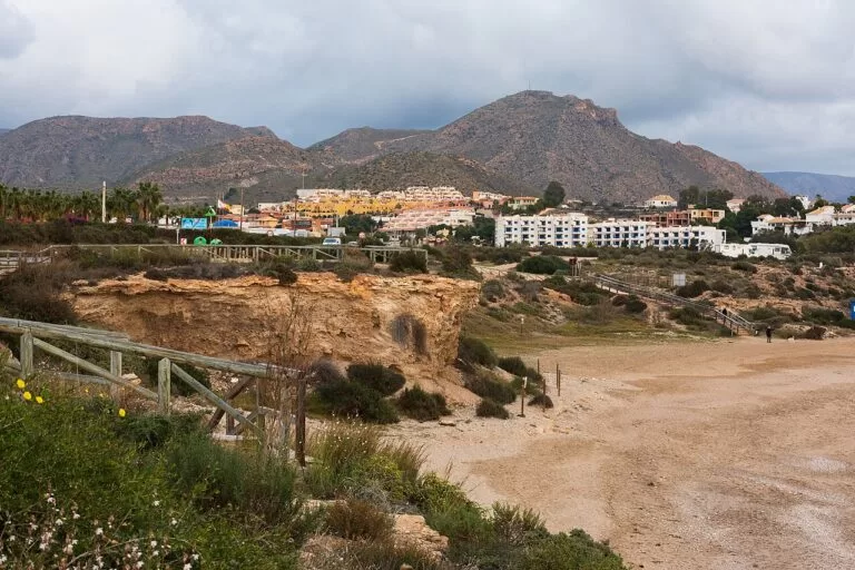 The sandy beach of El Mojón with the houses of Puerto de Mazarrón behind