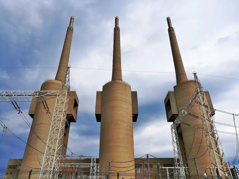 The tall concrete chimneys of the Sant Adria power station seen from the street