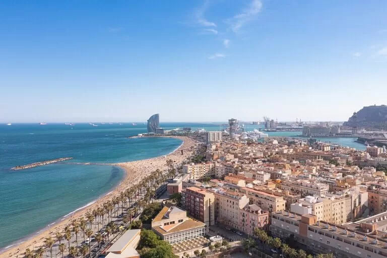 Aerial view of Barceloneta beach and Port Vell beside the sea