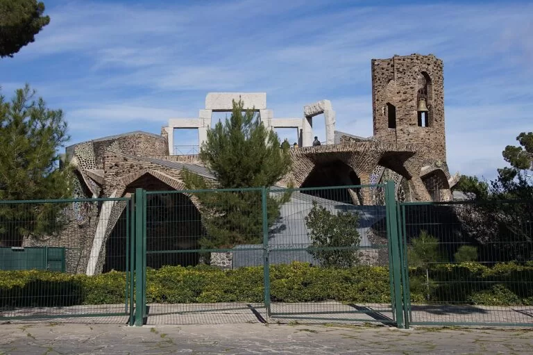 The stone crypt of the Colonia Guell church among pine trees
