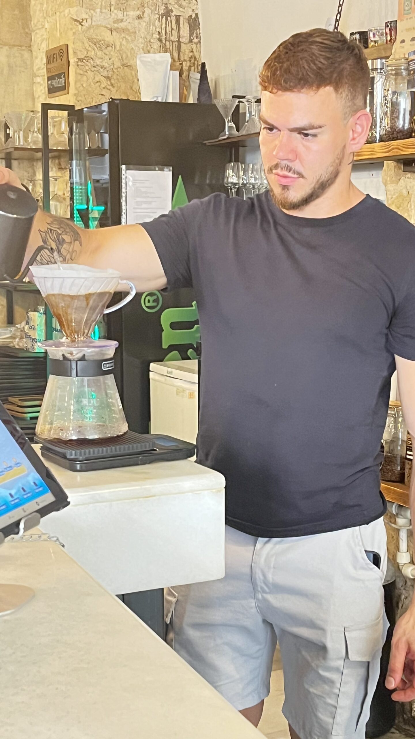 Barista pouring a V60 pour-over coffee at Madness Coffee in Alicante
