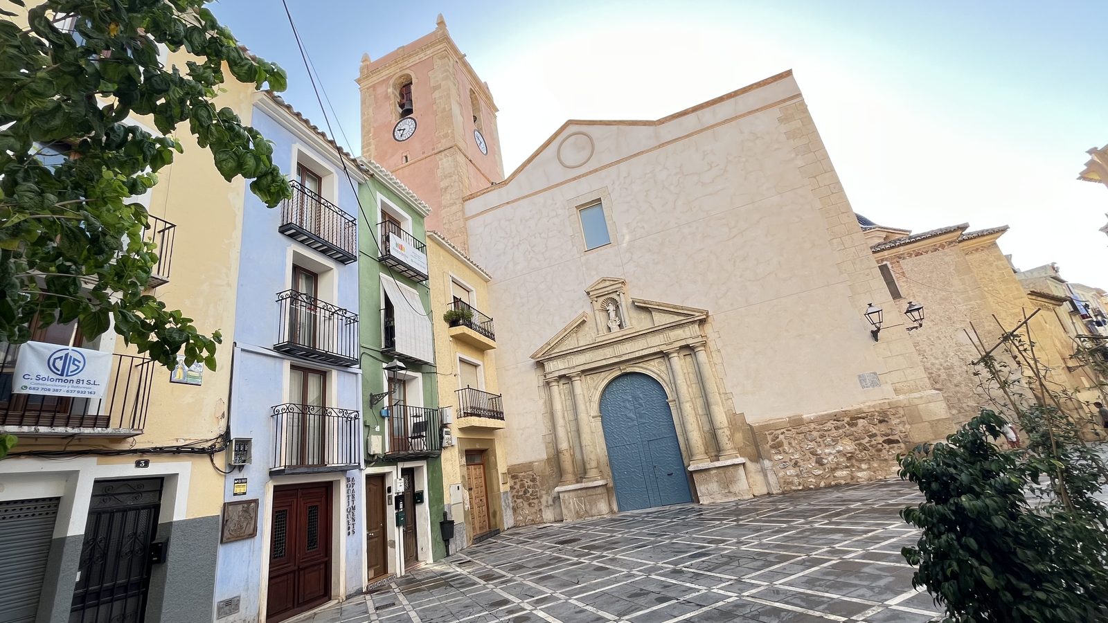 The fortress church of Nuestra Señora de la Asunción in Villajoyosa, with its Baroque portal and coloured houses on the Plaça de l'Església